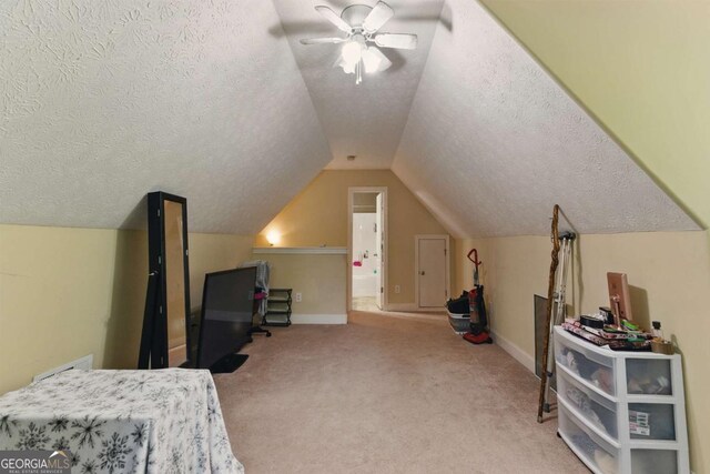 418 Whisper Wood Way, Locust Grove, GA 30248 - carpeted bedroom with a textured ceiling, vaulted ceiling, baseboards, and ceiling fan