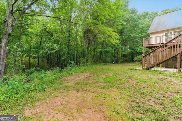 418 Whisper Wood Way, Locust Grove, GA 30248 - view of yard with stairs, a deck, and a view of trees
