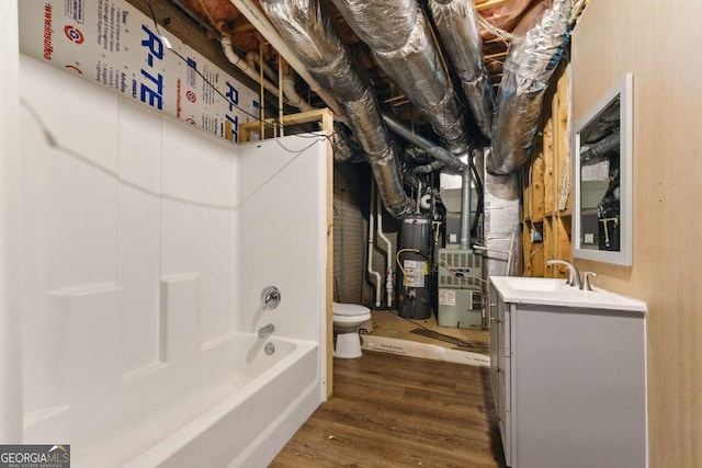 418 Whisper Wood Way, Locust Grove, GA 30248 - bathroom featuring wood finished floors, toilet, a tub to relax in, vanity, and water heater