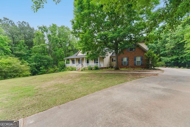 418 Whisper Wood Way, Locust Grove, GA 30248 - view of front of home with a porch, brick siding, a front yard, and driveway