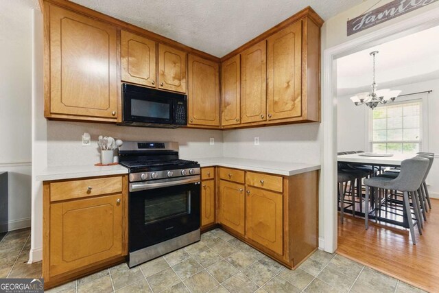 418 Whisper Wood Way, Locust Grove, GA 30248 - kitchen featuring black microwave, gas stove, a chandelier, light countertops, and brown cabinetry