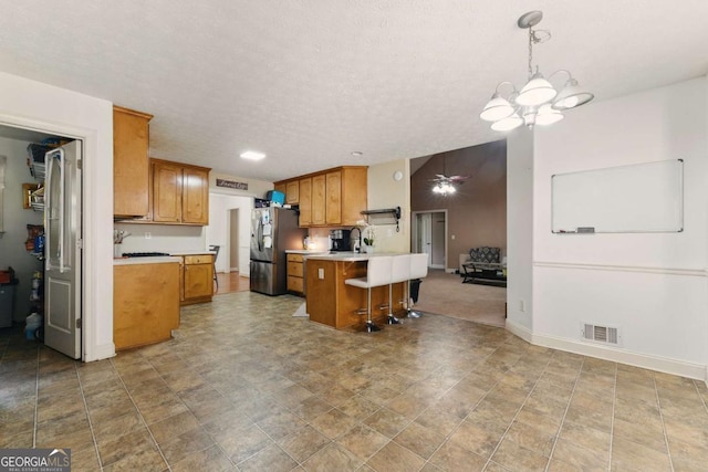 418 Whisper Wood Way, Locust Grove, GA 30248 - kitchen with freestanding refrigerator, light countertops, a peninsula, a kitchen breakfast bar, and a textured ceiling