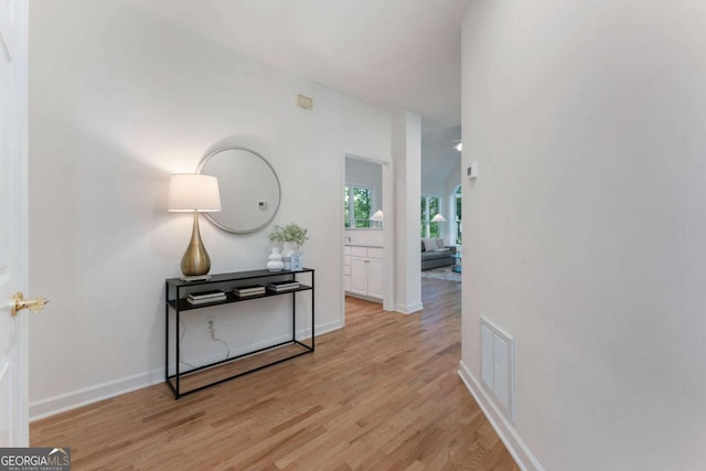 hallway featuring light wood-style flooring and baseboards