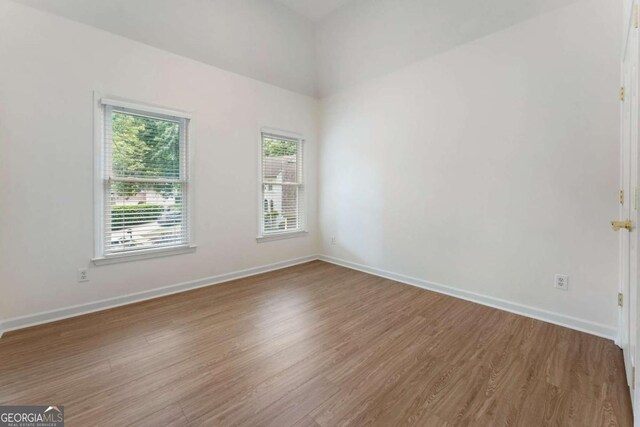 spare room featuring wood finished floors and baseboards