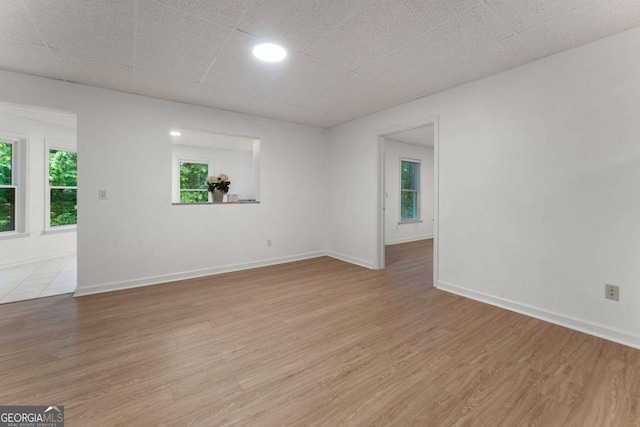 unfurnished room featuring light wood finished floors and baseboards