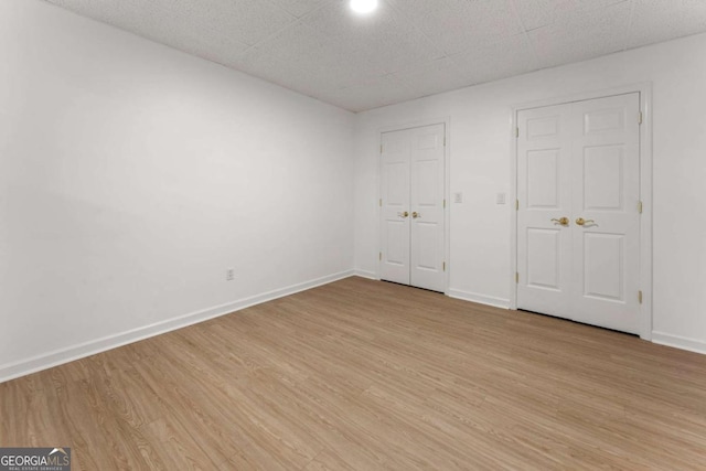 unfurnished bedroom featuring light wood-type flooring and baseboards