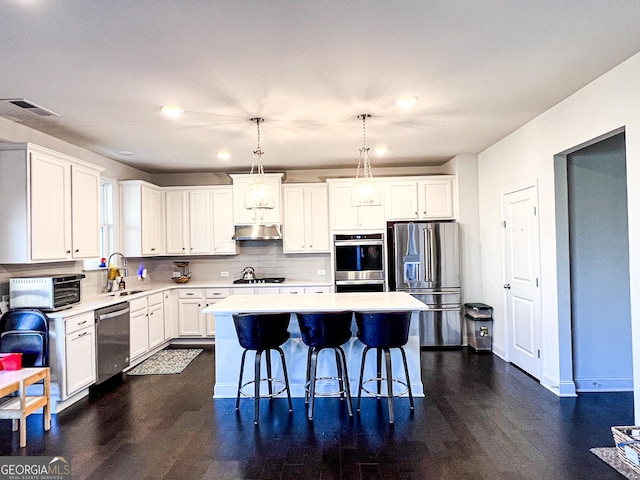 7860 Bristol Valley Dr, Cumming, GA 30028 - kitchen with stainless steel appliances, a sink, under cabinet range hood, light countertops, and recessed lighting