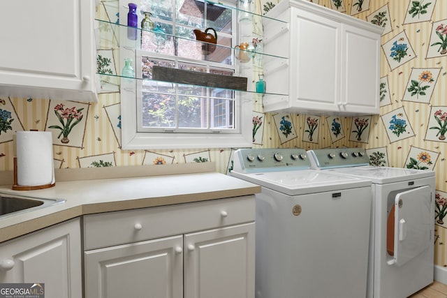 9274 Betony Wood Trl, Jonesboro, GA 30236 - laundry area with cabinet space, separate washer and dryer, and wallpapered walls