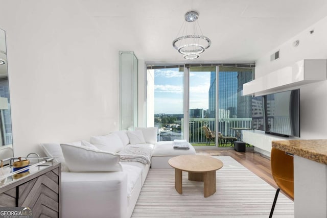 living room featuring floor to ceiling windows, a chandelier, and wood finished floors