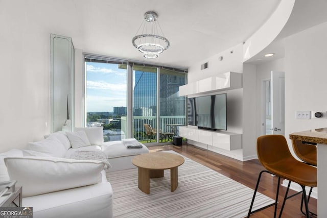 living room with wood finished floors, expansive windows, and a chandelier