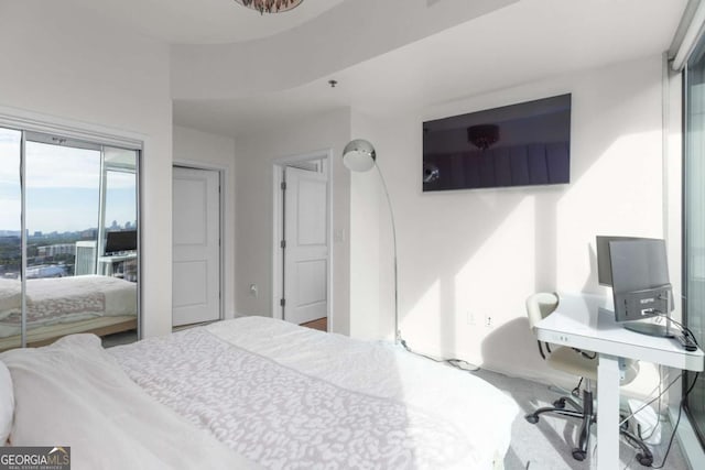 bedroom featuring an office area and baseboards