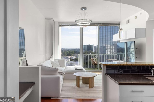 3324 Peachtree Rd NE Unit 1304, Atlanta, GA 30326 - living room with a wall of windows, wood finished floors, and a chandelier