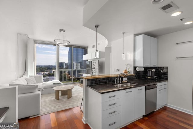 3324 Peachtree Rd NE Unit 1304, Atlanta, GA 30326 - kitchen featuring a sink, stainless steel dishwasher, dark countertops, a peninsula, and dark wood-style floors
