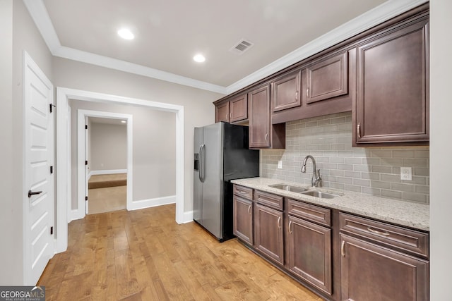859 Heritage Lake Way, Grayson, GA 30017 - kitchen featuring a sink, stainless steel fridge with ice dispenser, tasteful backsplash, ornamental molding, and light stone counters