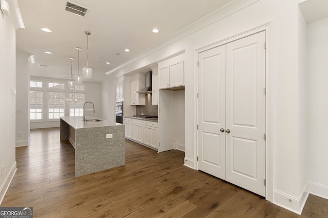 6790 Encore Blvd, Sandy Springs, GA 30328 - kitchen with wall chimney range hood, white cabinetry, stainless steel appliances, a center island with sink, and recessed lighting