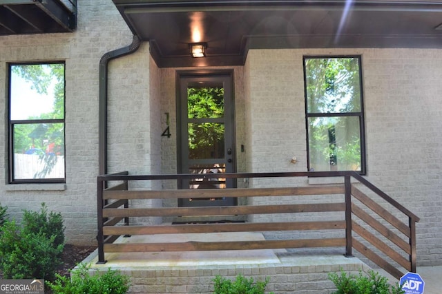 doorway to property featuring brick siding