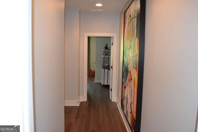 hall featuring baseboards and dark wood finished floors
