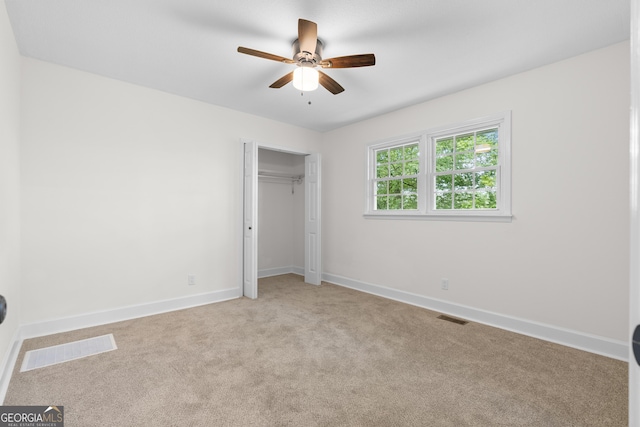 unfurnished bedroom with light colored carpet, baseboards, a closet, and ceiling fan