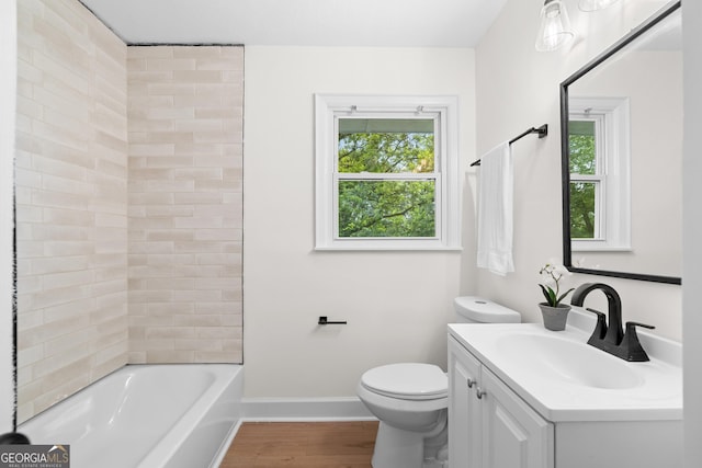bathroom featuring plenty of natural light, toilet, wood finished floors, and vanity