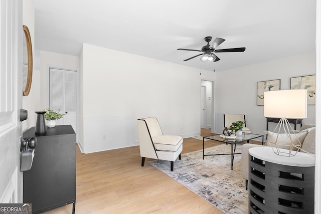 living room with light wood-style flooring and ceiling fan