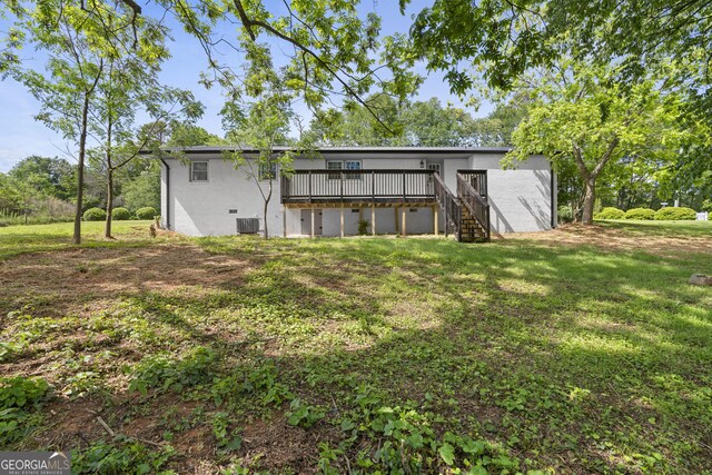 rear view of property featuring a deck, stairway, a lawn, stucco siding, and cooling unit