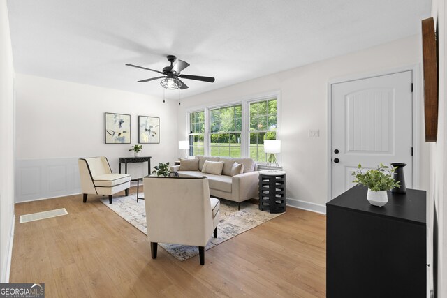 living area featuring light wood-style flooring and ceiling fan