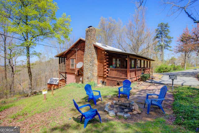 2425 Hines Gap Rd, Warm Springs, GA 31830 - view of side of property with log exterior, a chimney, an outdoor fire pit, and a wooden deck