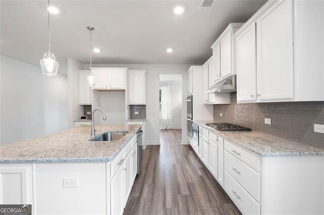 1809 Hanwoo Ln, Powder Springs, GA 30127 - kitchen with a sink, under cabinet range hood, dark wood-style flooring, white cabinets, and recessed lighting