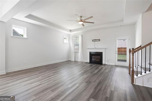 1809 Hanwoo Ln, Powder Springs, GA 30127 - unfurnished living room with a raised ceiling, ceiling fan, dark wood-type flooring, and stairs