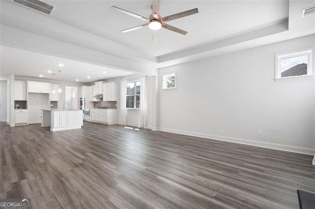 1809 Hanwoo Ln, Powder Springs, GA 30127 - unfurnished living room with a tray ceiling, recessed lighting, baseboards, a ceiling fan, and dark wood finished floors
