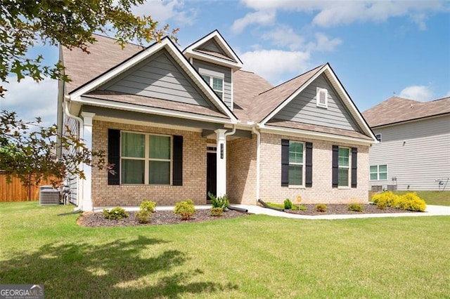 1809 Hanwoo Ln, Powder Springs, GA 30127 - craftsman-style house with covered porch, brick siding, a front yard, and central air condition unit