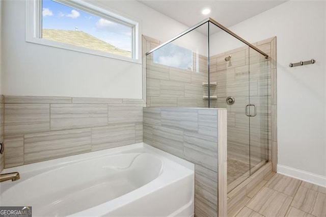 1809 Hanwoo Ln, Powder Springs, GA 30127 - bathroom featuring a stall shower, a bath, and baseboards