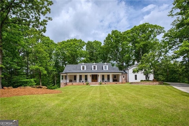 new england style home with covered porch and a front yard