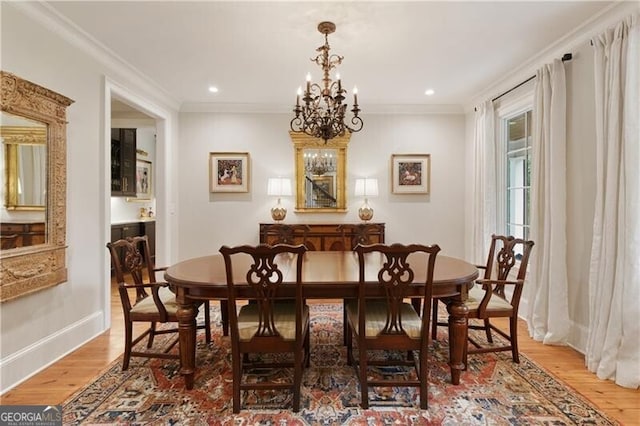 dining area featuring wood finished floors, a chandelier, baseboards, recessed lighting, and ornamental molding