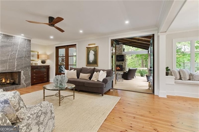 living room featuring a fireplace, crown molding, ceiling fan, wood finished floors, and recessed lighting