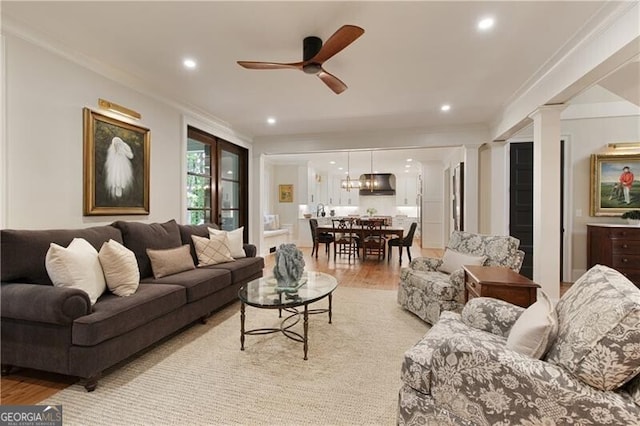living area with light wood-style flooring, ceiling fan, recessed lighting, ornamental molding, and ornate columns