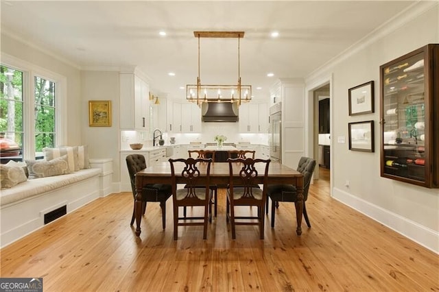 dining space featuring a chandelier, ornamental molding, light wood-style flooring, recessed lighting, and baseboards
