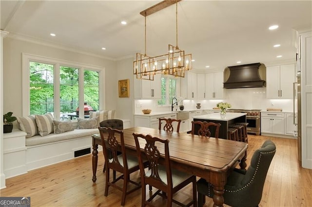 dining space with crown molding, light wood finished floors, a chandelier, and recessed lighting