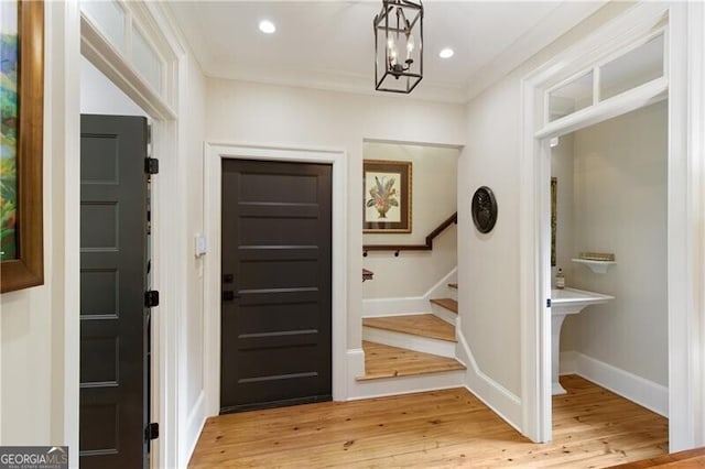 foyer entrance featuring stairs, light wood-type flooring, a chandelier, baseboards, and recessed lighting