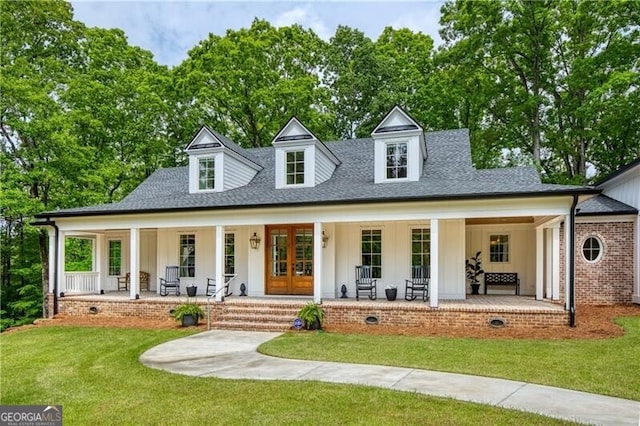 view of front of home with a porch, french doors, board and batten siding, and a front yard