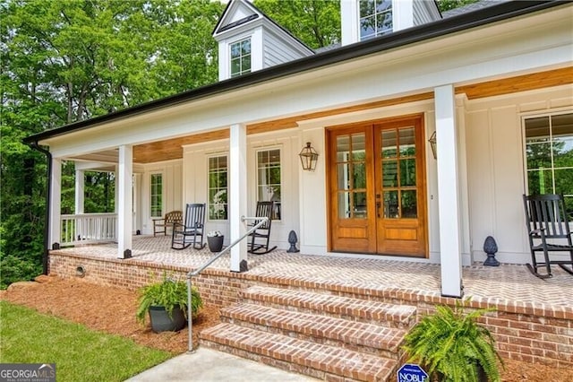 view of exterior entry with a porch and french doors