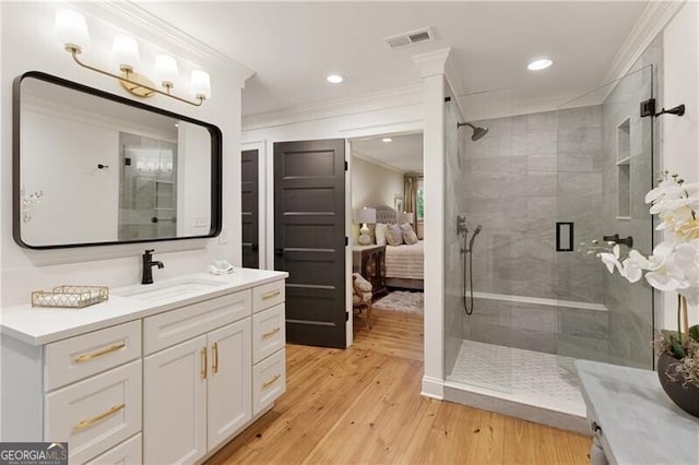 bathroom with ornamental molding, a shower stall, wood finished floors, connected bathroom, and vanity