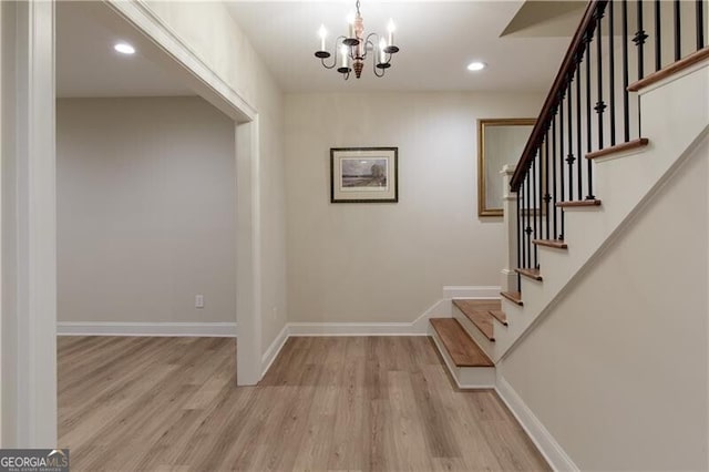 foyer entrance featuring light wood finished floors, a chandelier, stairs, baseboards, and recessed lighting