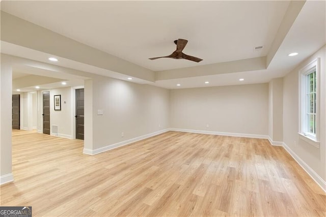 unfurnished room with light wood-style flooring, a raised ceiling, baseboards, recessed lighting, and a ceiling fan