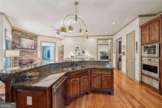 4162 Cumberland Point Dr, Gainesville, GA 30504 - kitchen with a sink, a warming drawer, appliances with stainless steel finishes, crown molding, and light wood finished floors
