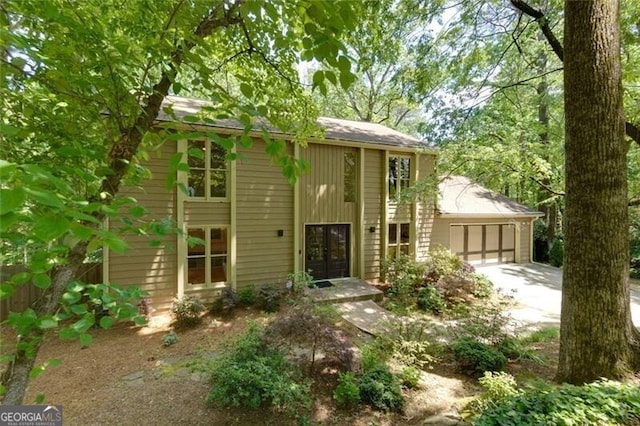 mid-century home with french doors, driveway, and an attached garage