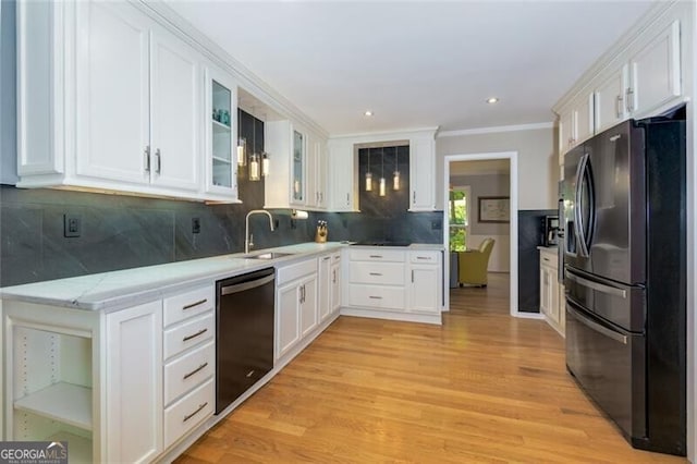 kitchen featuring black appliances, a sink, white cabinets, light wood-style floors, and glass insert cabinets