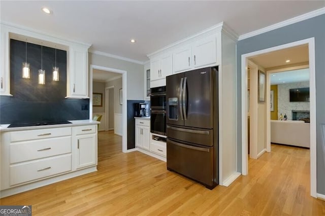 kitchen with black appliances, white cabinets, tasteful backsplash, light wood-type flooring, and crown molding