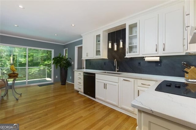 kitchen with black appliances, a sink, decorative backsplash, light wood-style floors, and white cabinets
