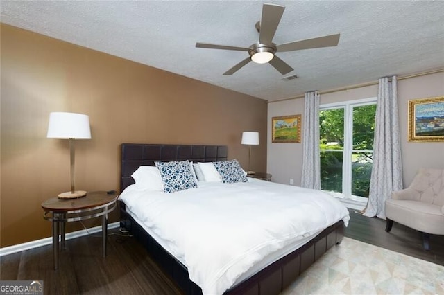 bedroom featuring wood finished floors, a textured ceiling, ceiling fan, and baseboards
